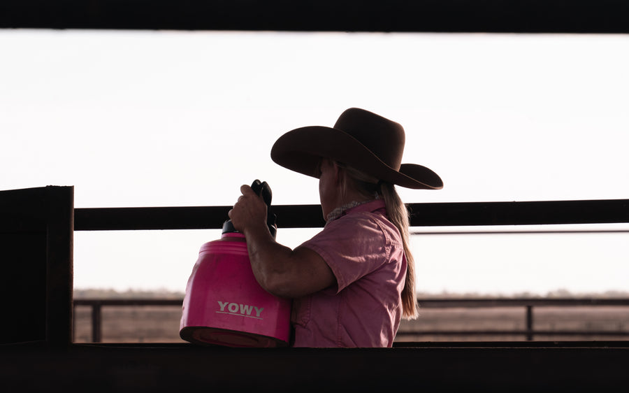 A stockman drinking from a red 6L Yowy in a buggy